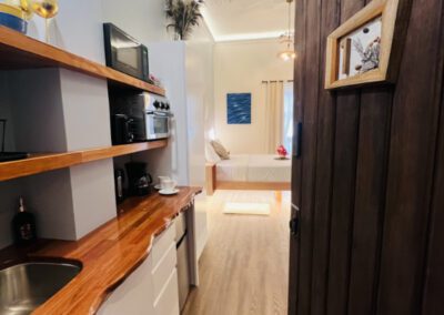 Entryway showing kitchenette with microwave and toaster oven, with floating bed in background.