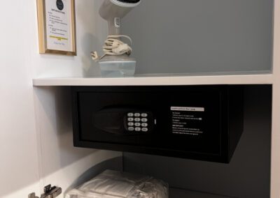 Safe,, clothes steamer and extra blanket situated in cupboard.