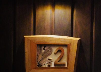 Locally designed and made apartment number sign on entrance.