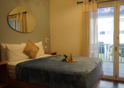 Floating queen bed with complimentary rum punch, showing view of verandah doors.