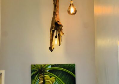 Locally designed and made artisnal light fitting, with coconut painting on wall in background.