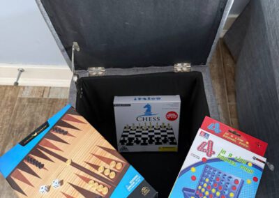 Games stored in footstool cabinet.