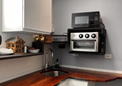 View of kitchen showing microwave and toaster oven, with crockery and complimentary tea and coffee.