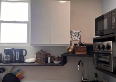 Kitchen showing microwave, toaster oven and mini fridge, with crockery and complimentary tea and coffee.