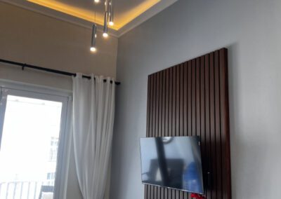 Wallmounted flat screen TV in living room showing verandah in background.