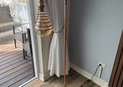 Locally designed artisnal floor lamp situated at edge of living room leading to verandah.