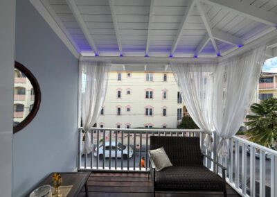 Verandah with a two seater sofa decorated with cushions overlooking the neighbourhood.