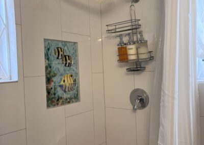 This shower has a hand-painted tile feature in the cubicle. Complimentary toiletries are provided with every rental.