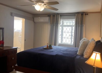 View of floating king bed with glimpse of bathroom in the background.