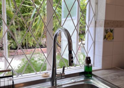 Kitchen sink with exterior kgarden view.