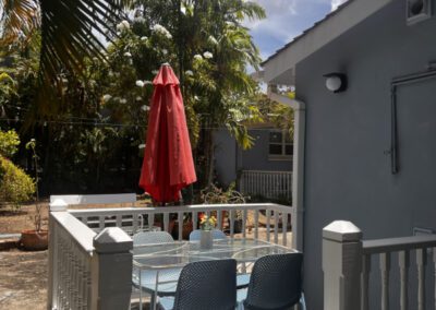 Rear exterior glass-topped patio table with four seats.