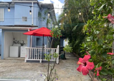 Rear patio showing enclosed seating area, barbeque and washer / dryer area.