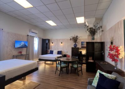 View on entry of bed 1 and bed 2 and most of the room showing also the four seater table, cabinets and three seater sofa.