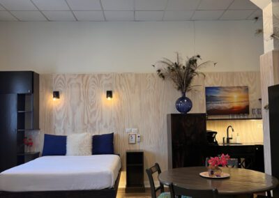 Four seater table positioned centrally in room with kitchenette in background.
