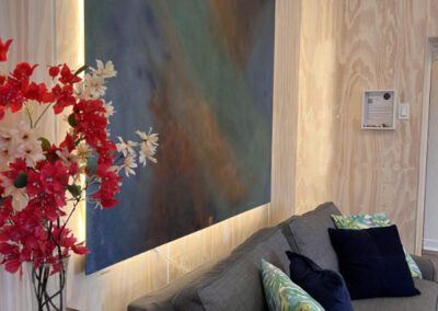 Three seater sofa with abstract backlit artwork.