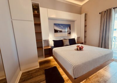 View of floating king bed with complimentary rum punch with flower arrangement with seascape artwork above.