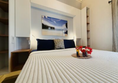View of floating king bed with complimentary rum punch with flower arrangement with seascape artwork above.