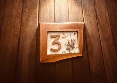 Locally designed and made apartment number sign on entrance.