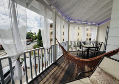 Verandah with hammock and four seater table and chairs.